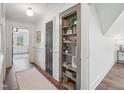 Hallway featuring hardwood floors, white walls, a decorative bookcase, and views into adjacent rooms at 511 Circle Dr, Burlington, NC 27215