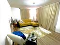 Stylish living room featuring hardwood floors, a comfortable yellow sofa, and a bright rug at 513 Orange St, Oxford, NC 27565