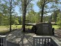 View of outbuildings in a large grassy backyard shaded by mature trees at 5138 Nc 56, Franklinton, NC 27525
