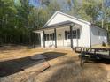Stylish new home showing white siding and black trim, complemented by the natural surroundings and a convenient trailer at 5875 Green Pine Rd, Cedar Grove, NC 27231