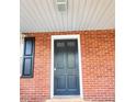 Close-up of the front door on a classic brick facade with black shutters at 919 E Main St, Haw River, NC 27258