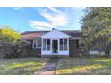 Traditional brick home with a cozy enclosed porch and mature shade trees at 919 E Main St, Haw River, NC 27258