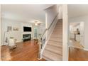 Bright living room features a fireplace, hardwood floors, and staircase at 9904 Erinsbrook Dr, Raleigh, NC 27617