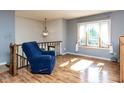 Sunlit living room with hardwood floors, large window, and cozy blue armchair at 103 Wesker Cir, Durham, NC 27703
