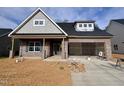 Charming brick home with gray shingles, two-car garage, and unfinished landscaping at 1073 Fairhaven Dr # 52, Mebane, NC 27302
