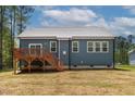 Back exterior of a blue single-story home with a wooden deck and a well-maintained lawn at 115 Buckskin Dr, Louisburg, NC 27549