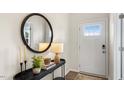 Bright entryway with a white front door with a glass window and an elegant round mirror at 1204 Pavo Path, Wendell, NC 27591