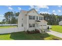 Beautiful two-story home with green shutters, attached garage, and well-manicured lawn at 1209 Huffington Oak Dr, Willow Springs, NC 27592