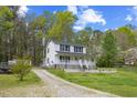 Two-story home with a white exterior, complemented by a gravel driveway and a spacious front yard at 124 Maluli Dr, Oxford, NC 27565