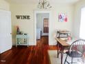Cozy dining room features hardwood floors, 'wine' decor, vintage chandelier, and natural light at 1308 Wake Forest Rd, Raleigh, NC 27604