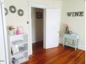 Bright living room with hardwood floors, decorative mirrors and wine themed decor at 1308 Wake Forest Rd, Raleigh, NC 27604