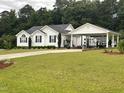 Traditional home featuring white siding, black shutters, a covered carport, and a well-manicured lawn at 132 Crystal Pl, Benson, NC 27504