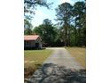 Long driveway to house with basketball hoop in a lush, green, wooded area at 136 Scramble Rd, Erwin, NC 28339