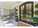 Inviting covered front porch with a swing, elegant double doors, and decorative potted plants at 143 Sallyport Ct, Raleigh, NC 27603