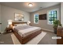 This primary bedroom is staged with a wood-framed bed, white rug, and two bright, sunlit windows at 145 Brannigan Pl, Cary, NC 27511