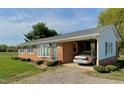 A charming brick ranch home with attached carport, set amidst a tranquil yard at 1829 Stewart Farm Rd, Henderson, NC 27537