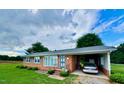 Charming brick ranch home with manicured lawn and attached carport providing functional curb appeal at 1829 Stewart Farm Rd, Henderson, NC 27537