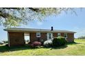 A brick ranch home featuring a back door entry and well-maintained landscaping at 1829 Stewart Farm Rd, Henderson, NC 27537