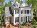 Charming two-story home featuring white siding, black shutters, and a well-manicured front yard with chairs at 2520 Ashley Ct, Raleigh, NC 27607