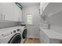 Well-organized laundry room with modern washer and dryer, ample storage cabinets, and a bright window at 2520 Ashley Ct, Raleigh, NC 27607