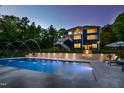 The beautifully lit in-ground pool with fountain features creates a relaxing backyard retreat at 255 Seven Island Rd, Pittsboro, NC 27312
