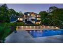 The sparkling in-ground pool with fountains and patio lighting creates a backyard oasis at 255 Seven Island Rd, Pittsboro, NC 27312