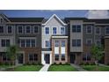 Exterior rendering of a three-story townhome showcasing brick and siding details, plus a well-maintained lawn at 344 Chesapeak Commons St # 138, Garner, NC 27529