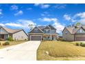 Lovely home with gray siding, stone accents, a long driveway, and a neatly kept lawn at 350 Stephens Way, Youngsville, NC 27596