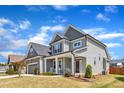 Beautiful two-story home with gray siding, stone accents, manicured lawn, and inviting curb appeal at 350 Stephens Way, Youngsville, NC 27596