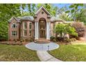 Stunning brick home featuring a grand entrance with stately columns and lush landscaping at 417 Swans Mill Xing, Raleigh, NC 27614