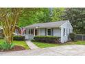 Attractive single-story home with gray siding, lush landscaping, and a cozy, covered front porch at 423 N Main St, Wendell, NC 27591