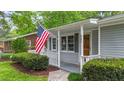Close up of charming home with covered porch, gray siding, and neat landscaping at 423 N Main St, Wendell, NC 27591