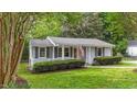 Inviting single-story home featuring gray siding, lush green lawn, and charming covered front porch at 423 N Main St, Wendell, NC 27591