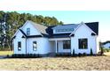 Beautiful two-story home with white siding, black trim, and a well-manicured lawn, showcasing modern farmhouse style at 4330 Medicus Ln, Franklinton, NC 27525