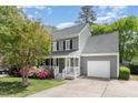 Gray two-story home with a covered front porch, attached garage, and beautifully landscaped front yard at 5033 Knightsbridge Way, Raleigh, NC 27604