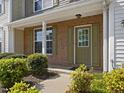 Close-up of a townhouse entrance with a brick facade, complemented by green shutters and trim at 5044 Brooke Lauren Ln, Raleigh, NC 27616