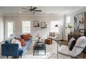 Bright living room with a stylish blue couch, ceiling fan, and large windows at 52 E American Marigold Dr # 63, Benson, NC 27504