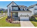 Beautiful two-story home featuring a white garage door, stone accents, a landscaped yard, and an inviting entryway at 5616 Horsewalk Cir, Raleigh, NC 27606