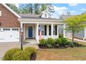 Inviting front porch with white columns, black shutters, and a vibrant blue front door at 713 Catherine Lake Ct, Fuquay Varina, NC 27526