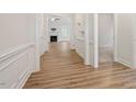 Bright hallway with hardwood floors leading to an open living space and fireplace at 713 Catherine Lake Ct, Fuquay Varina, NC 27526