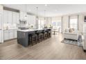 Bright and open kitchen with stainless steel appliances, island seating, and a view into the living area at 809 Walker Ridge Way, Willow Springs, NC 27592