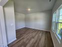 Spacious bedroom showcasing wood-look floors, neutral paint, and natural light from the multiple windows at 84 Grove Township Way, Angier, NC 27501