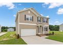 Inviting two-story home with a two-car garage, manicured lawn, and a welcoming entrance at 84 Grove Township Way, Angier, NC 27501