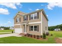 Beautiful home featuring neutral siding, a two-car garage, and a neatly landscaped front yard at 84 Grove Township Way, Angier, NC 27501