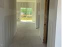 A bright hallway leads to a sunlit room with access to a wooden balcony, showcasing the home's layout at 84 Grove Township Way, Angier, NC 27501
