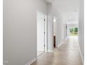 Bright hallway with hardwood floors leads to various rooms and a view of the backyard through sliding glass doors at 84 Grove Township Way, Angier, NC 27501