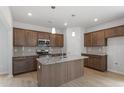 Beautiful kitchen boasts a large island with a sink, modern pendant lighting, and plenty of counter space at 84 Grove Township Way, Angier, NC 27501