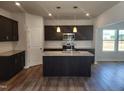 Modern kitchen with granite countertops, dark cabinets, stainless steel appliances and a center island at 84 Grove Township Way, Angier, NC 27501