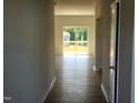 Bright, open-concept living room featuring wood-look flooring and sliding glass doors to the outdoor deck at 84 Grove Township Way, Angier, NC 27501