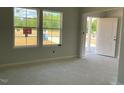 Living room bathed in natural light with large windows and white trim details at 84 Grove Township Way, Angier, NC 27501